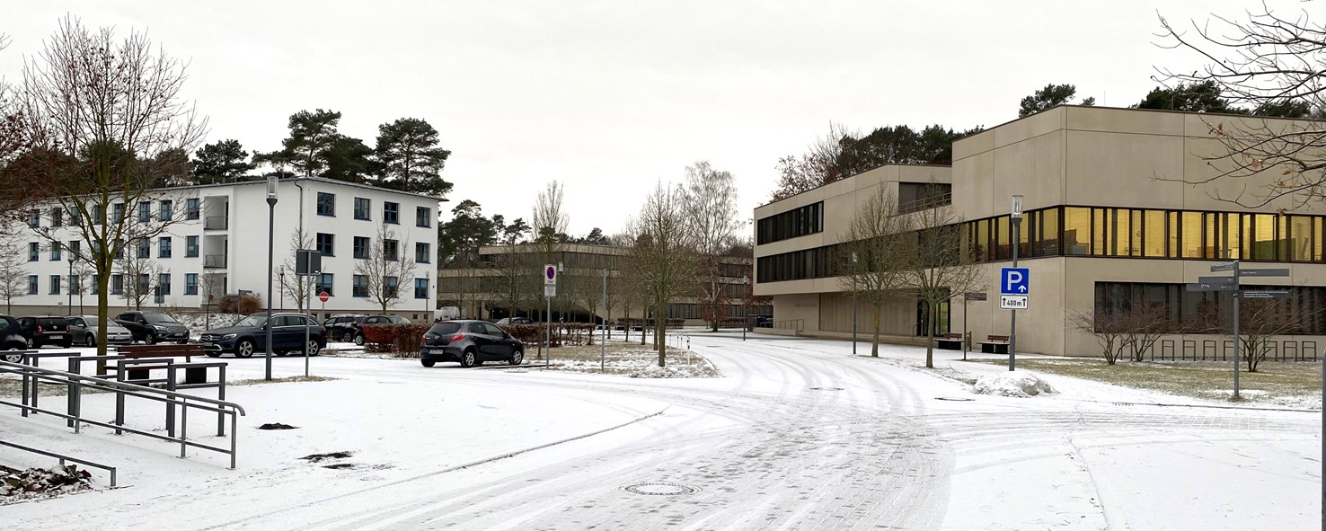 Bild: Das Bild zeigt die Straße mit Blick auf das Haus 3, das Hörsaalgfebäude und das Seminargebäude an einem weißen Wintermorgen.