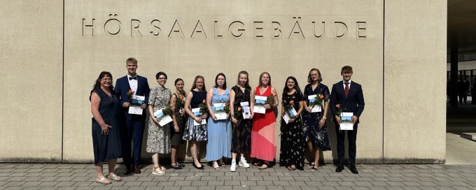 Absolventinnen und Absolventen vor dem Hörsaalgebäude